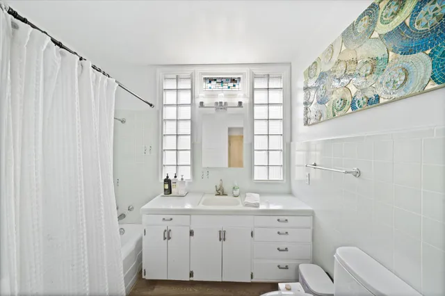 a bathroom with a granite countertop sink a toilet and a large mirror
