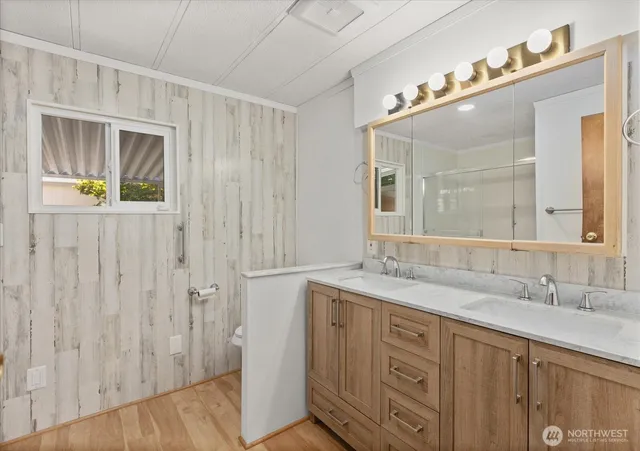 a spacious bathroom with a granite countertop sink a mirror and a shower