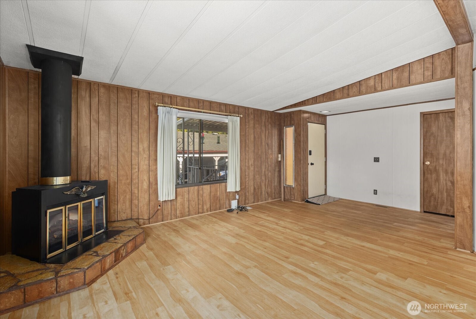 815 124th Street Southwest, Unit 133 Everett, WA 98204 - Photo 6 of 38 a view of an empty room with wooden floor and a window
