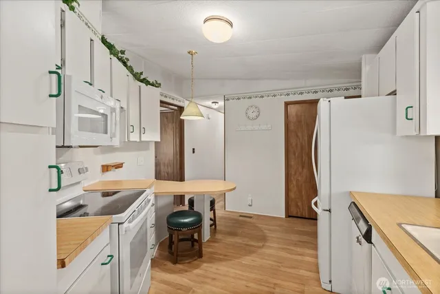 a kitchen that has a refrigerator a sink and a stove