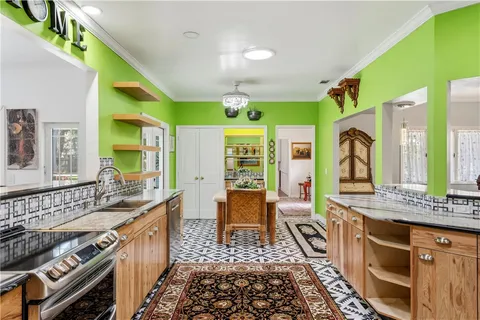 a large kitchen with stainless steel appliances granite countertop a stove and a dining table