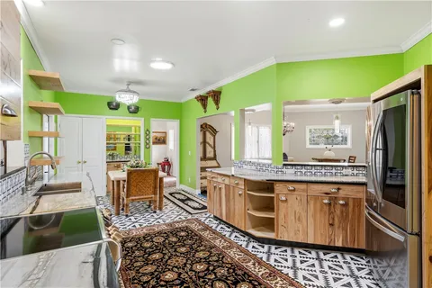 a kitchen with stainless steel appliances kitchen island granite countertop a table chairs in it and wooden floors