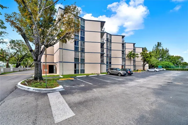a view of a apartment with a yard and plants