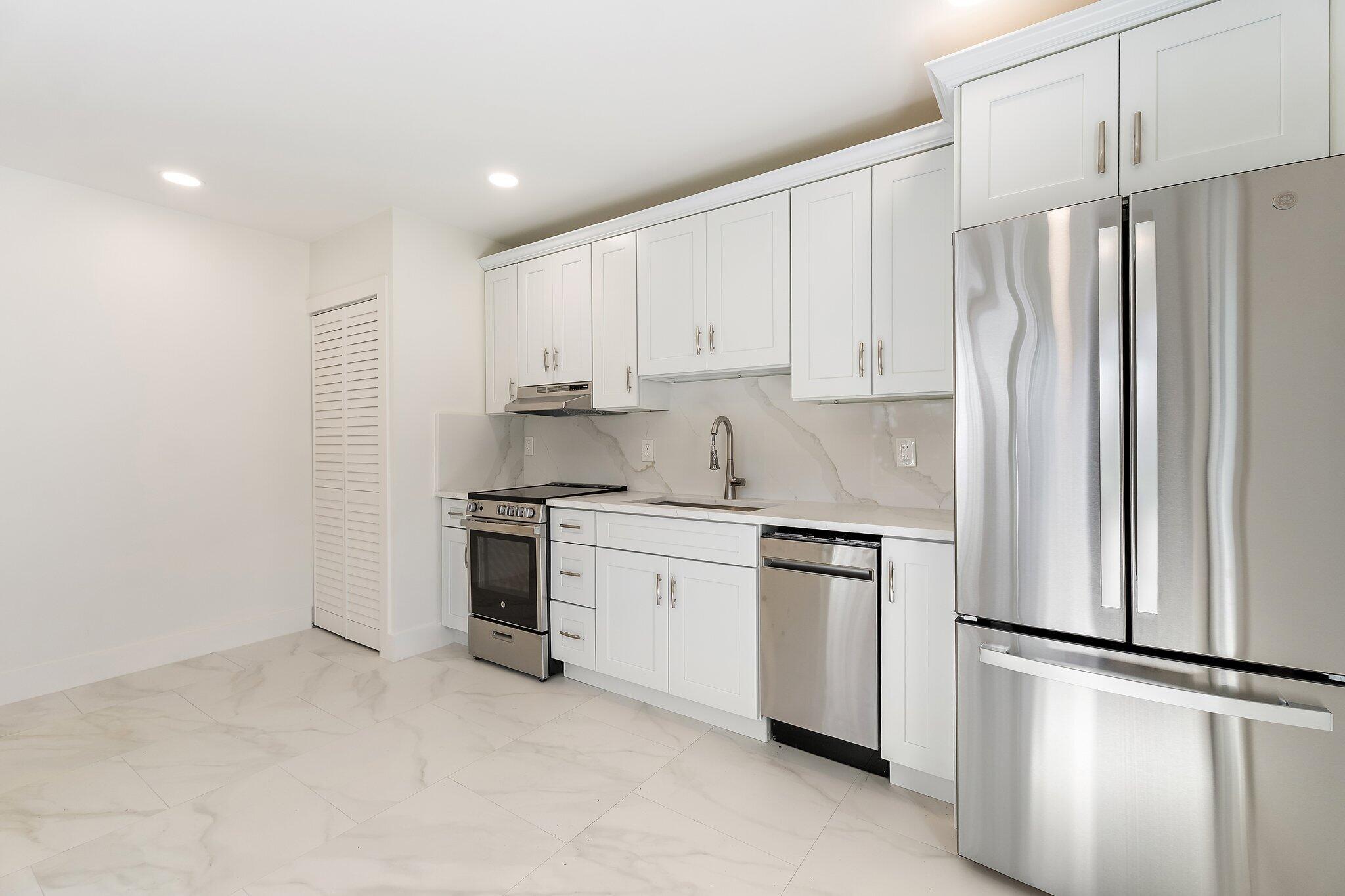 4015 Washington Road West Palm Beach, FL 33405 - Photo 28 of 31 a kitchen with stainless steel appliances granite countertop a refrigerator sink and white cabinets