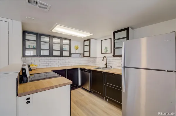 a kitchen with a refrigerator sink and cabinets