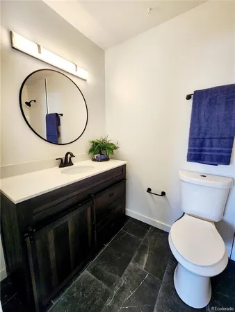 a bathroom with a toilet a sink and a mirror