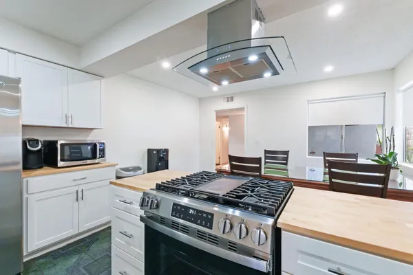 a kitchen with stainless steel appliances granite countertop a stove and a refrigerator