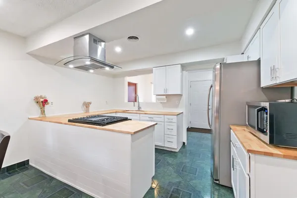 a kitchen with stainless steel appliances a sink stove and refrigerator