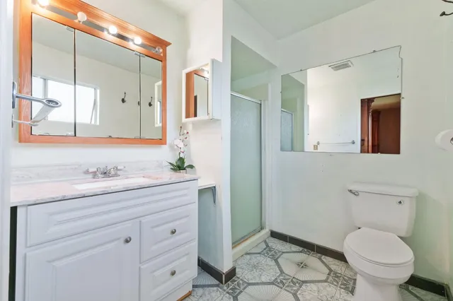 a bathroom with a granite countertop toilet sink and mirror