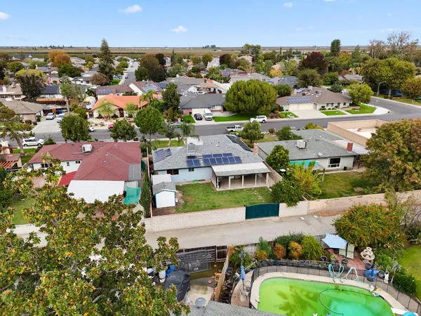 an aerial view of residential houses with outdoor space and a lake view