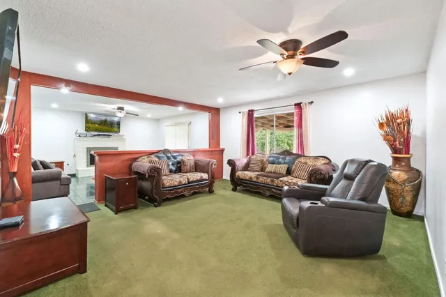 a living room with furniture and a ceiling fan