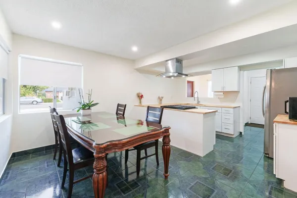 a kitchen with a table chairs and refrigerator
