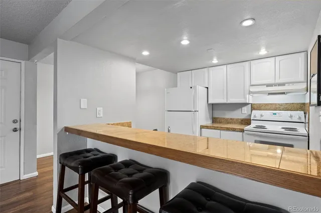 a kitchen with a sink refrigerator and cabinets