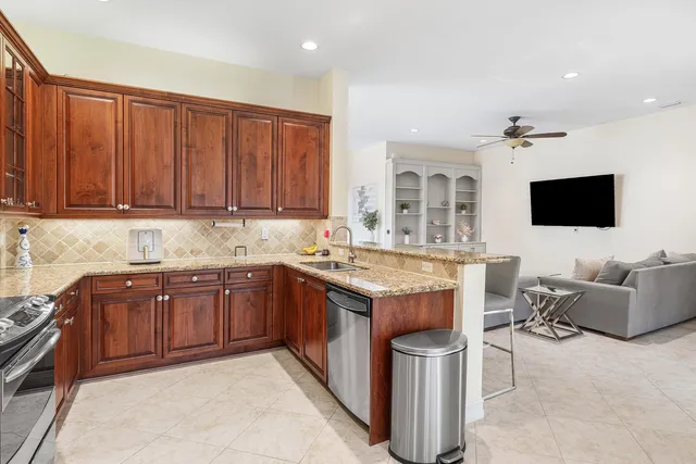 a kitchen with stainless steel appliances granite countertop a sink and a stove