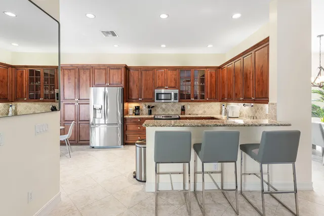 a kitchen with stainless steel appliances granite countertop a sink and a stove