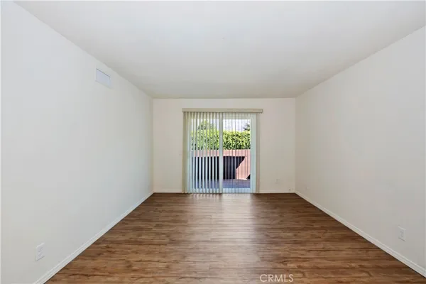 a view of a hallway with wooden floor and closet
