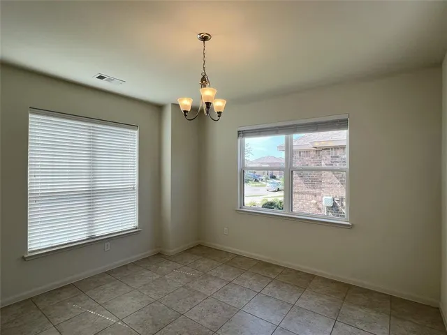 an empty room with windows and chandelier