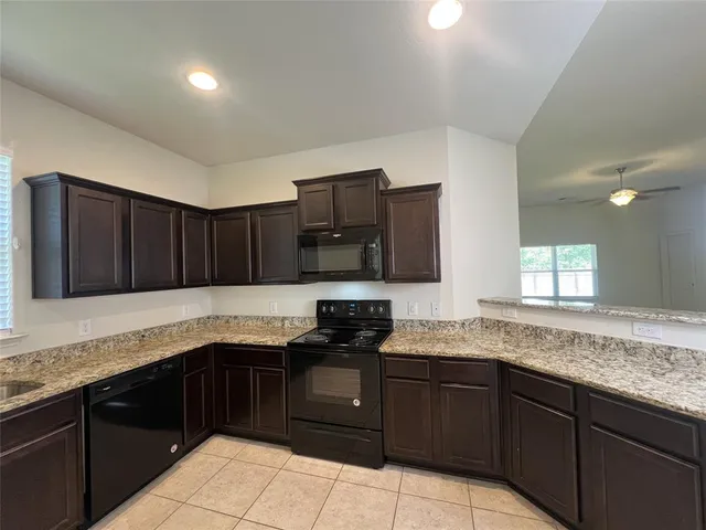 a kitchen with granite countertop a sink and cabinets