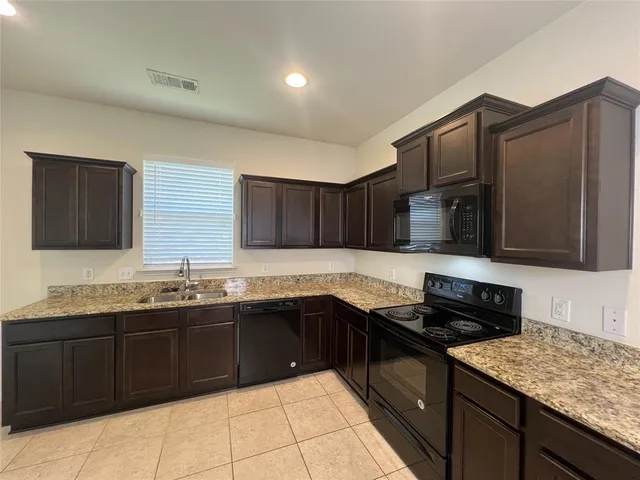 a kitchen with stainless steel appliances granite countertop a sink and a stove