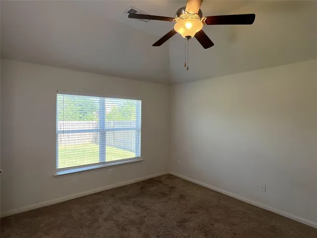 an empty room with a window and a fan