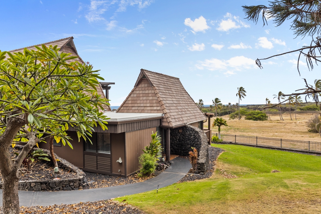 95-789 Ninole Loop Road, Unit 42 Naalehu, HI 96772 - Photo 17 of 30 a view of a terrace with a table and chairs under an umbrella
