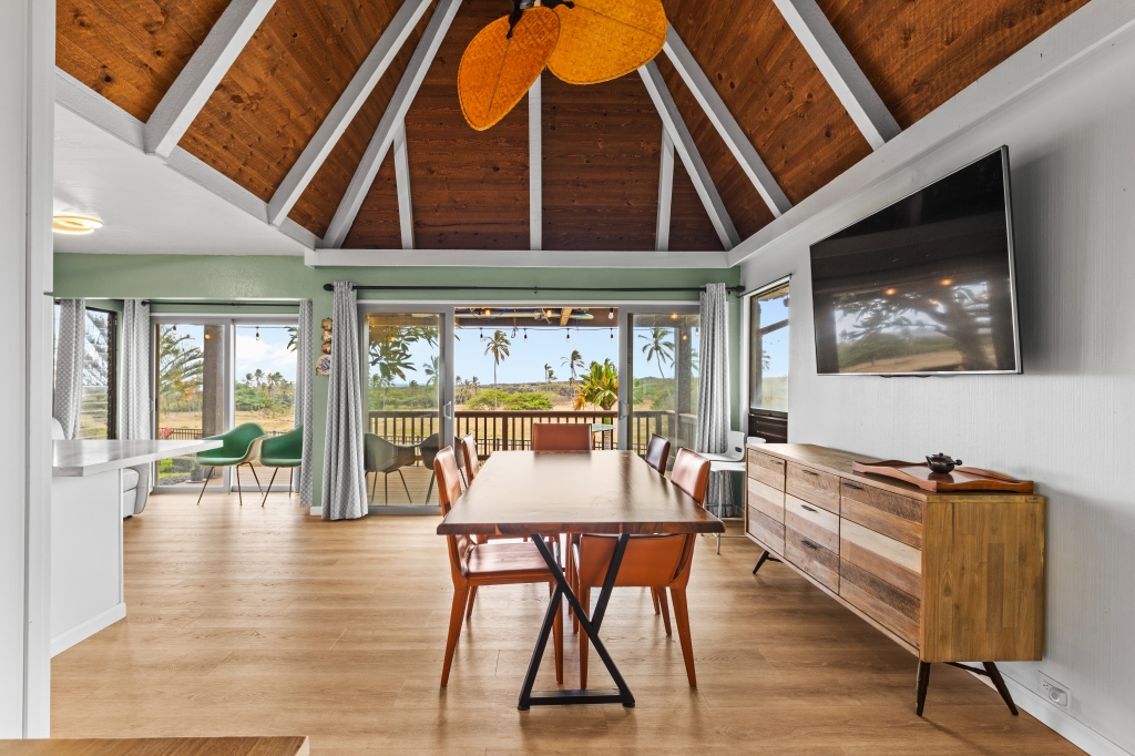 95-789 Ninole Loop Road, Unit 42 Naalehu, HI 96772 - Photo 3 of 30 a dining room with wooden floor and large windows