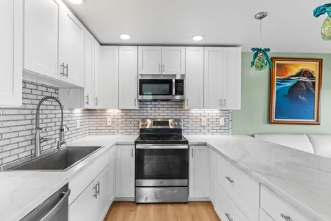 a kitchen with a sink stove and microwave