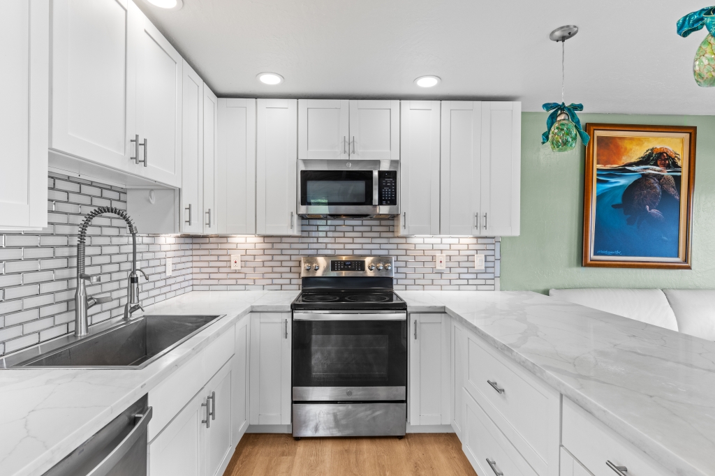 95-789 Ninole Loop Road, Unit 42 Naalehu, HI 96772 - Photo 6 of 30 a kitchen with a sink stove and microwave