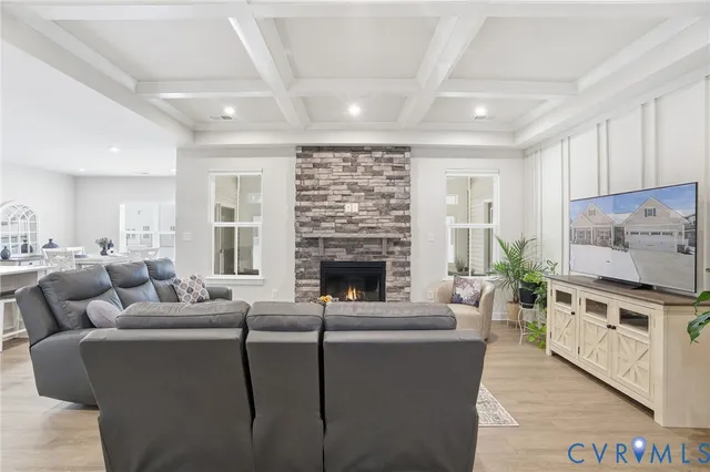 a living room with furniture a fireplace a flat screen tv and a window