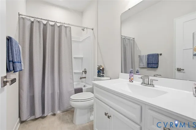 a bathroom with a sink a toilet and shower curtain