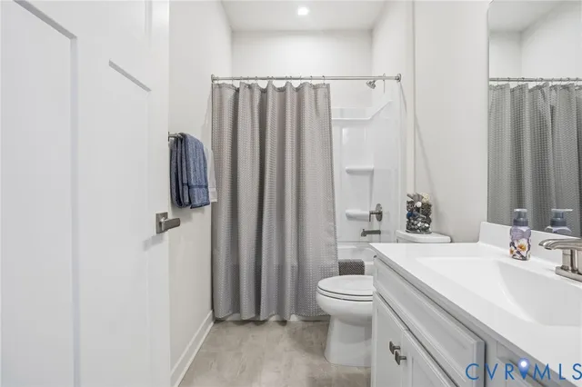 a bathroom with a sink a toilet a mirror and shower curtain
