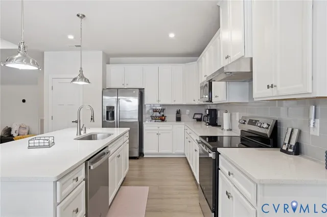 a kitchen that has a lot of cabinets in it and appliances