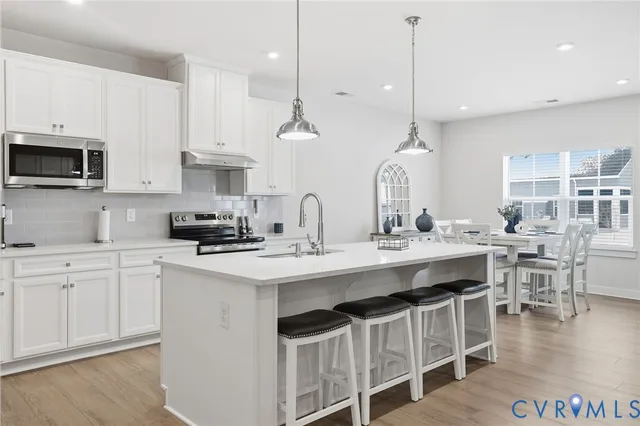 a kitchen with kitchen island granite countertop a sink a center island and cabinets