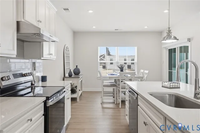 a kitchen with a sink stove and cabinets