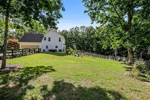 a backyard of a house with lots of green space and fountain