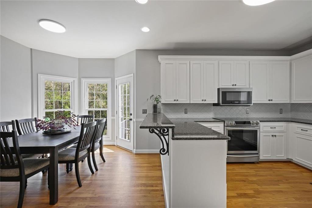 2203 Arbor Hill Road Canton, GA 30115 - Photo 34 of 65 a kitchen with a table chairs stove and cabinets