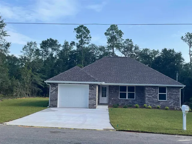 a front view of a house with a garden and yard