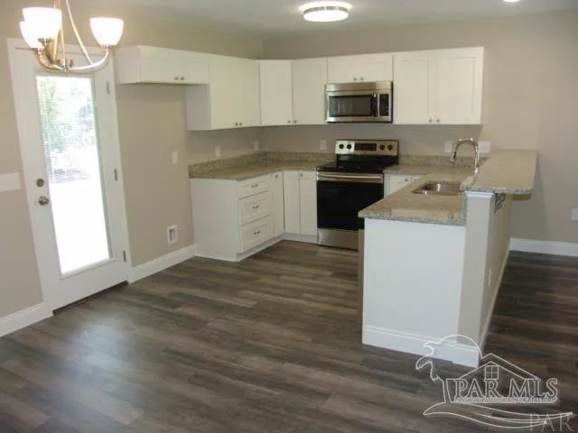 a kitchen with a sink a stove top oven and cabinets