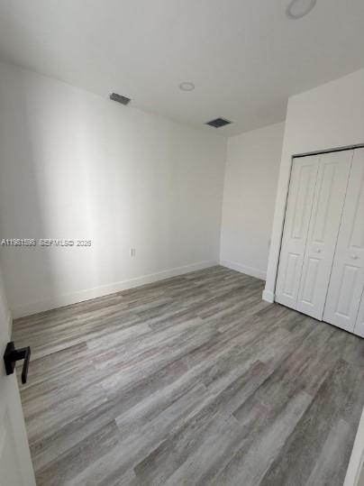 913 Northwest 46th Street, Unit 2 Miami, FL 33127 - Photo 4 of 7 an empty room with wooden floor and cabinet