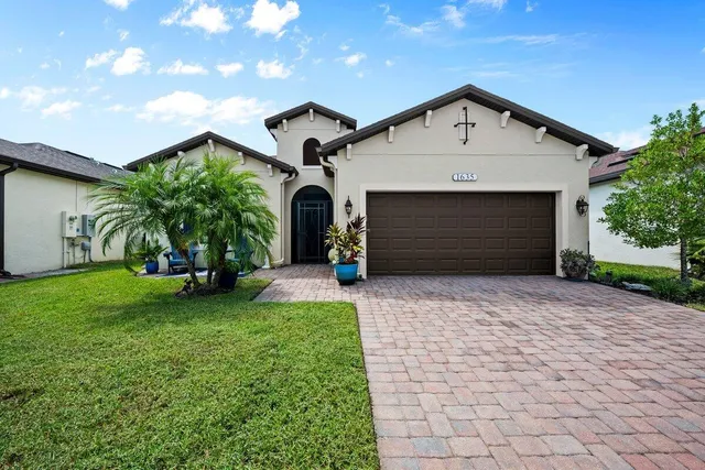 a front view of a house with a yard and garage