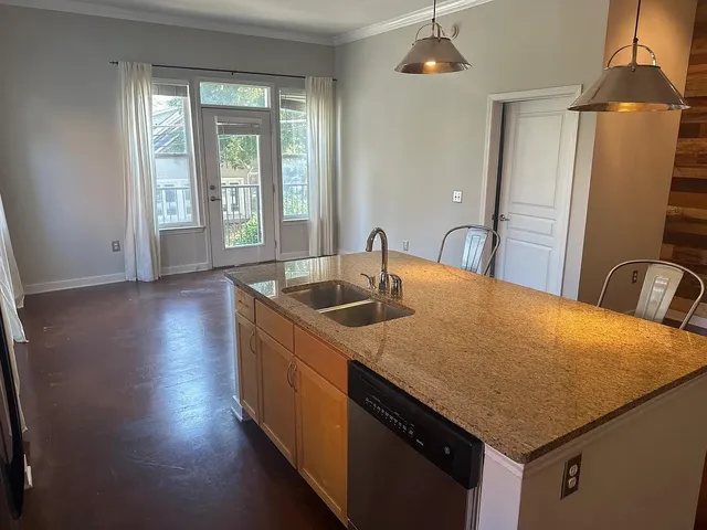 a kitchen with stainless steel appliances granite countertop a sink a stove and a wooden floors