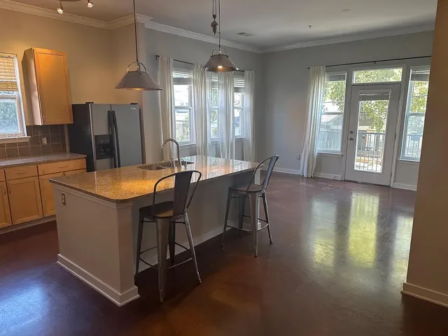 a room with stainless steel appliances kitchen island granite countertop furniture and a large window