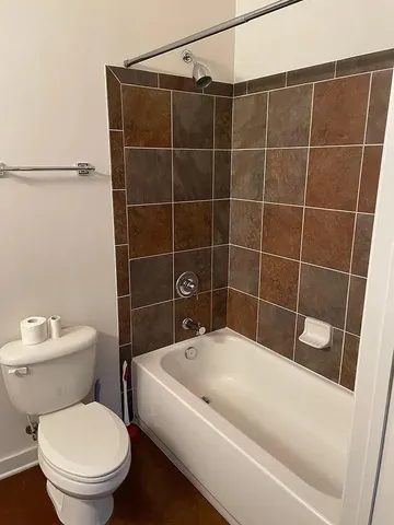a bathroom with a toilet and a shower