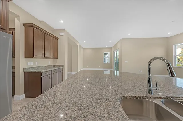a kitchen with kitchen island granite countertop a sink stainless steel appliances and cabinets