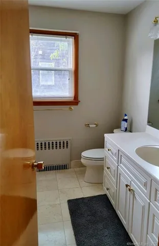 a bathroom with a sink a toilet and a window