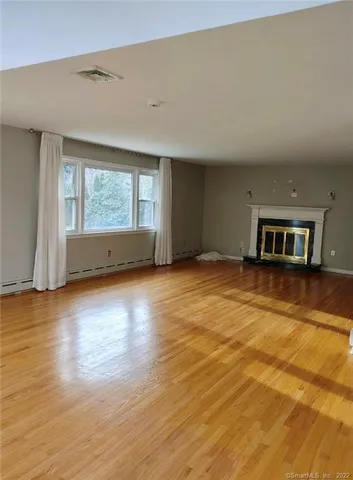 an empty room with wooden floor and a window