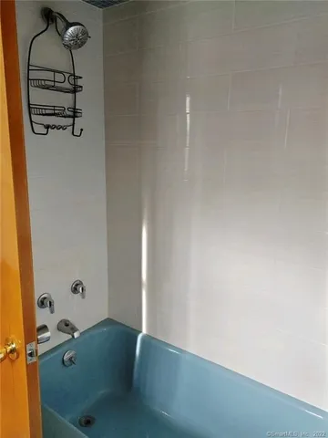 a bathroom with a tub and mirror