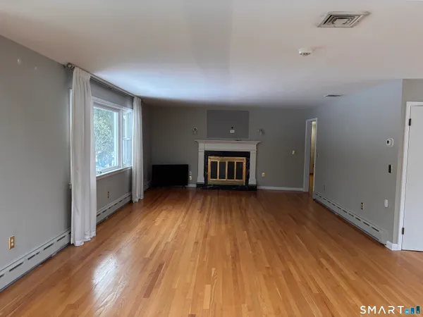 wooden floor in an empty room with a window
