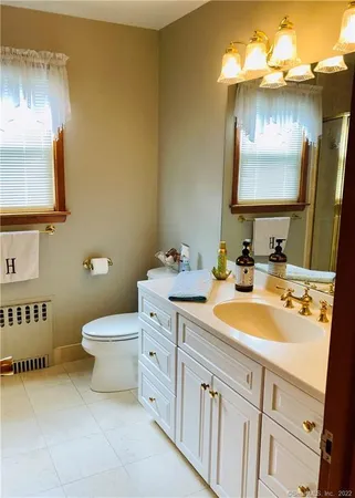 a bathroom with a toilet sink and mirror