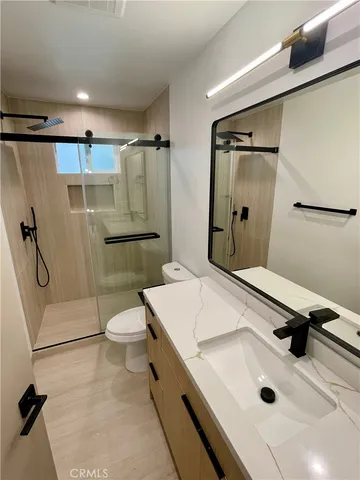 a bathroom with a sink a toilet and shower